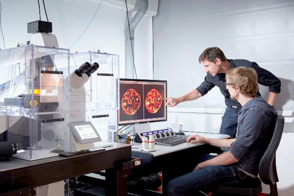 Two researchers at the microscope