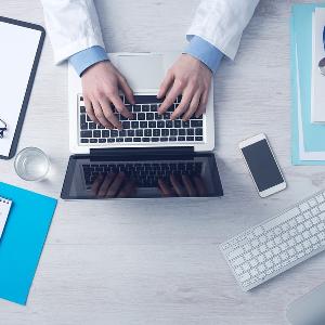 Schreibtisch einer Person mit Laptop Schreibtisch einer Person mit Laptop