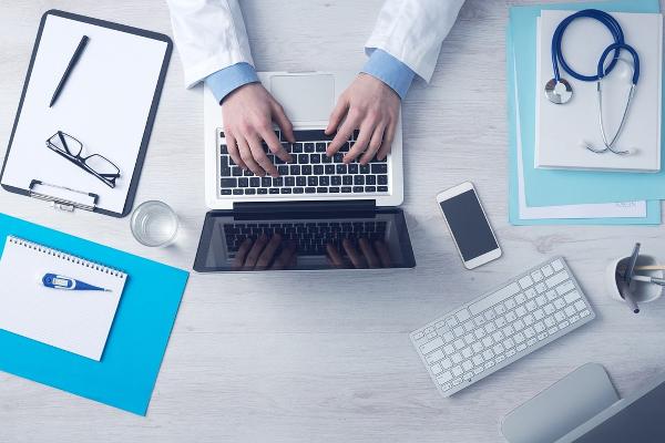 Schreibtisch einer Person mit Laptop
