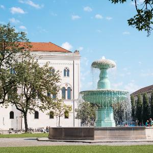 Ansicht des Geschwister-Scholl-Platz mit Brunnen und Hauptgebäude der LMU von Süden