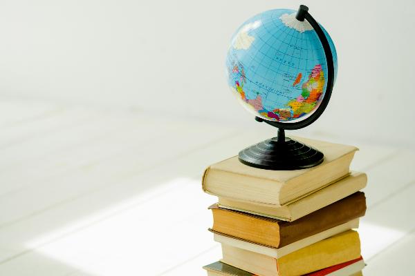 kleiner Globus steht auf Bücherstapel