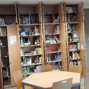 Raum mit geöffneten Schränken voller Bücher, Ordner und Lernmaterialien