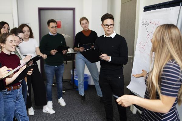 Eine Gruppe Studierender in einem Seminarraum