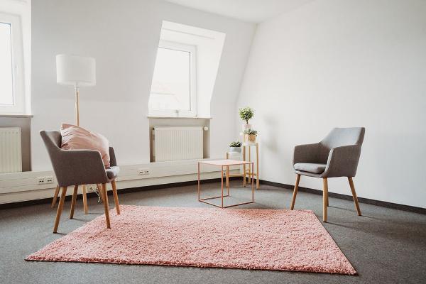 Therapieraum mit zwei Sesseln und einem Tisch in der Mitte