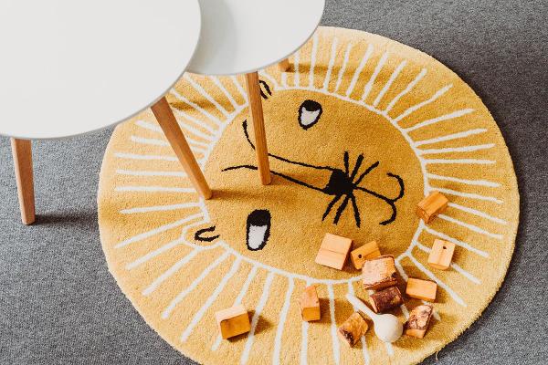 Therapieraum mit Tisch, Löwen-Teppisch und hölzernen Bauklötzen für Kinder