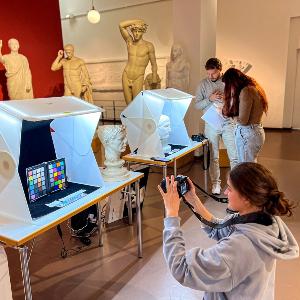 Photo of students scanning and photographing statues in a museum.