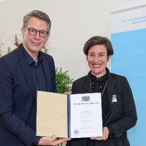 Frau Dr. Räuchle mit der Urkunde und dem Wissenschaftsminister Markus Blume