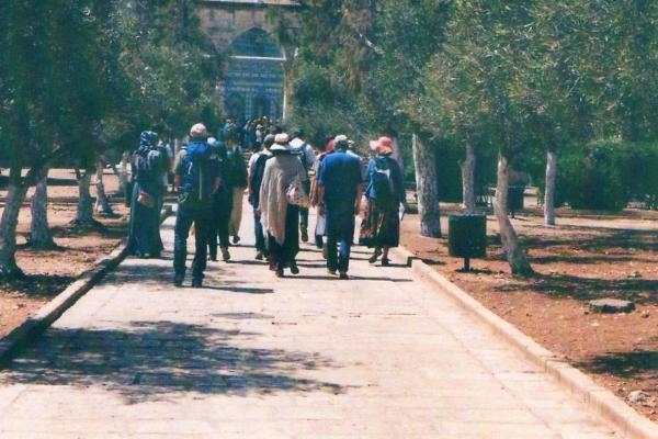 Menschen von hinten, die auf den Haram von Jerusalem zugehen.