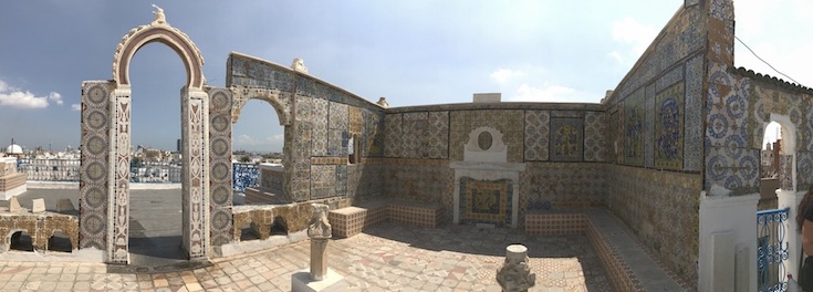 Freistehende Wände mit vielfältigen Mosaiken und Verzierungen auf einem Hausdach.