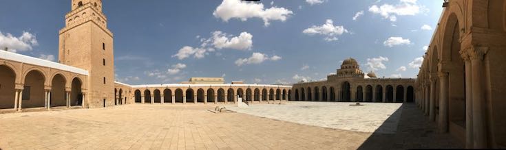 Sehr großer leerer Innenhof einer Moschee unter blauem Himmel.