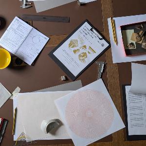 Ein archäologischer Arbeitsplatz mit antiken Keramikscherben, Messschieber, Profilzeichnungen und Fachliteratur