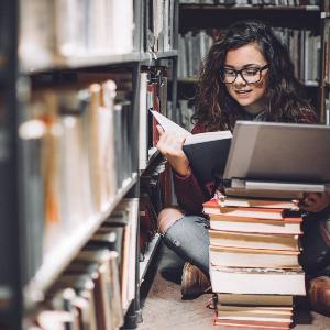 Promovendin vor einem Bücherstapel