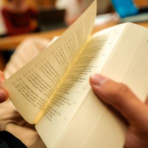 Hand, die in einem Buch blättert