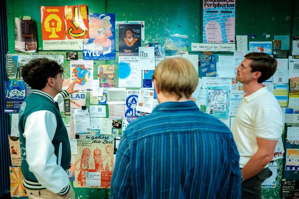 Personen vor Aushängen im Gebäude Schellingstr. 3