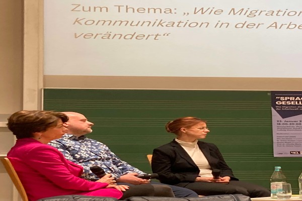 Nahaufnahme der Bühne auf dreisitzende Personen, die diskutieren