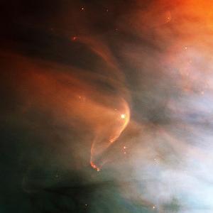 wind from the star LL Orionis generating a bow shock (the bright arc) as it collides with material in the surrounding Orion Nebula.