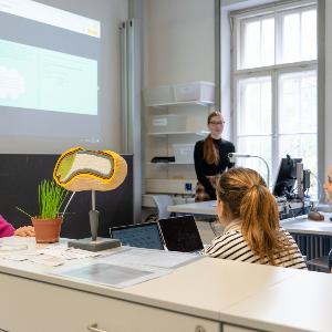 Seminar mit Dozentin und vortragender Studentin