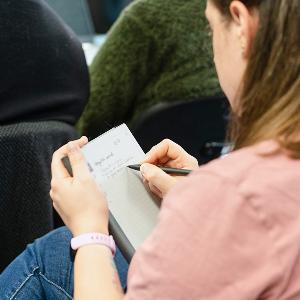 Studentin schreibt in Notizbuch