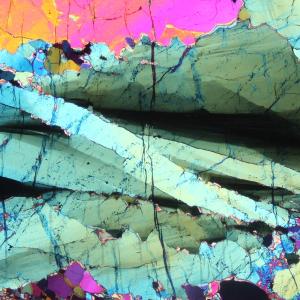 Polarized light micrograph (crossed polars, inserted compensator plate) of olivine kink bands, peridotite from the Finero complex, Southern Alps, N-Italy, image width ≈ 3 mm