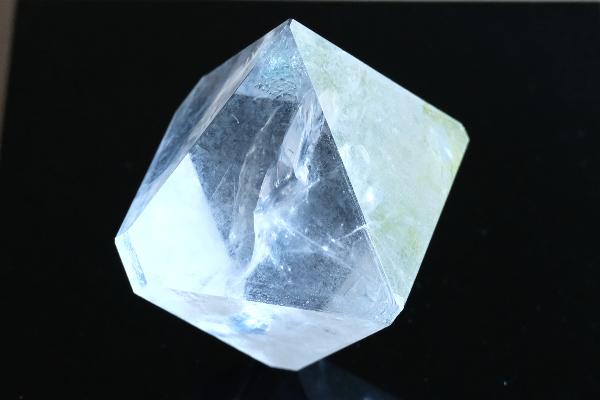 Transparenter farbloser Alaun-Kristall vor schwarzem Hintergrund