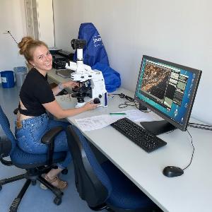 PhD student working on a microscope.