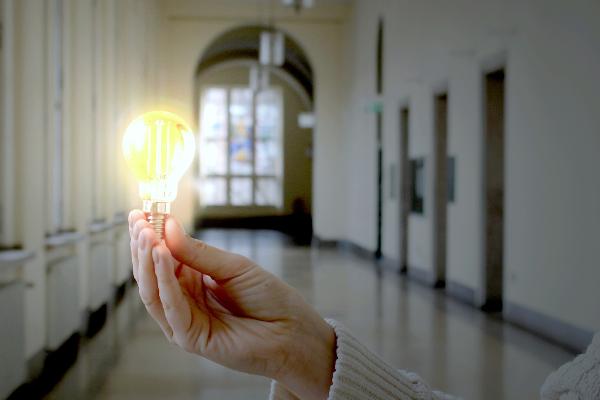 Hand mit leuchtender Glühbirne