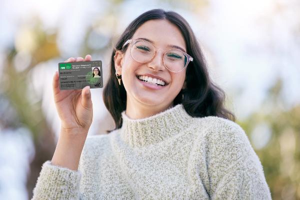 Symbolic image: A young woman holding an LMUcard