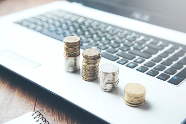 Symbolbild: Münzen liegen auf einem aufgeklappten Laptop