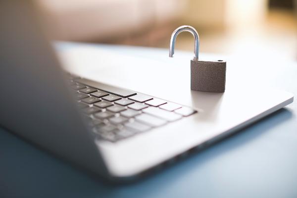 Symbolbild: Ein geöffnetes Vorhängeschloss steht auf einer Laptoptastatur.