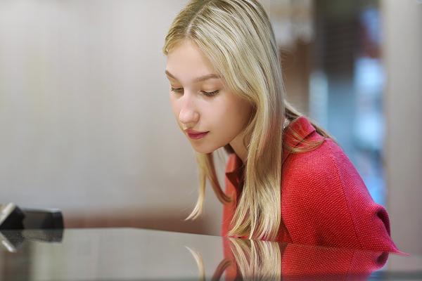 Symbolbild: Eine junge Frau schaut in eine Vitrine.