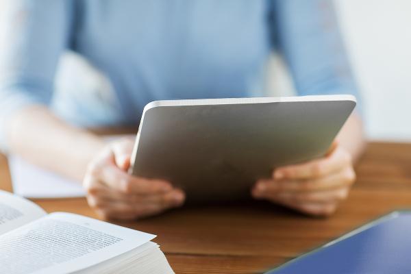 Symbolbild: Zwei Hände halten ein Tablet fest.