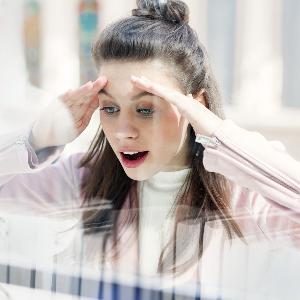 Symbolbild: Eine junge Frau schaut in ein Schaufenster.