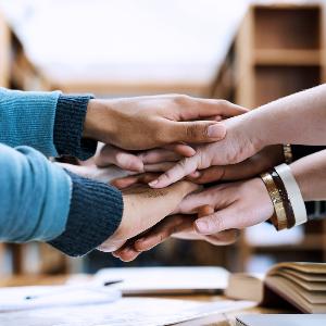 Symbolbild: Mehrere Personen legen ihre Hände aufeinander.