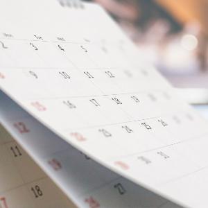 Close-up-White-Paper-Schreibtischkalender mit verschwommenem Bokeh-Hintergrundtermin und Business-Meeting-Konzept