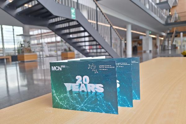 Invitation to the 20th anniversary of MCN & GSN with LMU Biocenter Foyer in background
