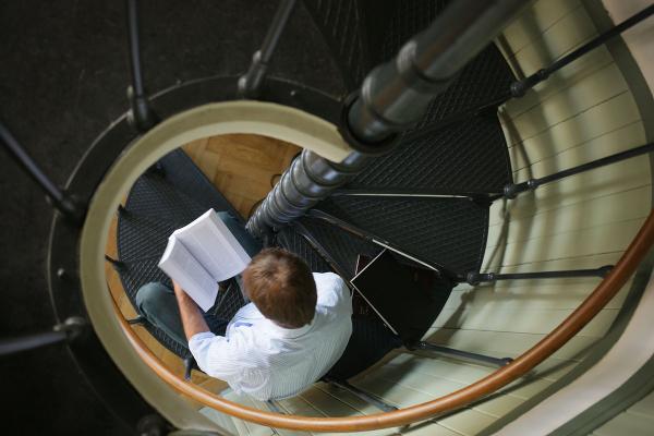 Researcher on spiral staircase in the philosophy library of the LMU