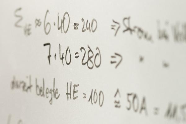 Mathematical equations written in black marker on a whiteboard
