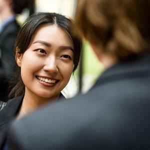 Nahaufnahme einer lächelnden Frau im Gespräch bei einem Career Event der LMU.