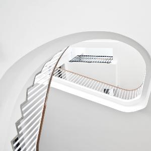 Eine weiße Wendeltreppe im Theologikum der LMU | © LMU Eine weiße Wendeltreppe im Theologikum der LMU