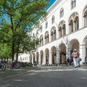 LMU Hauptgebäude von außen mit Studierenden und vielen Fahrrädern