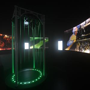 Ein dunkler Raum in einer Ausstellung, mit einem Exponat in der Mitte.