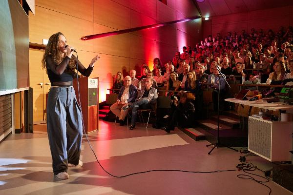 Female speaker in front of an audience in a lecture hall