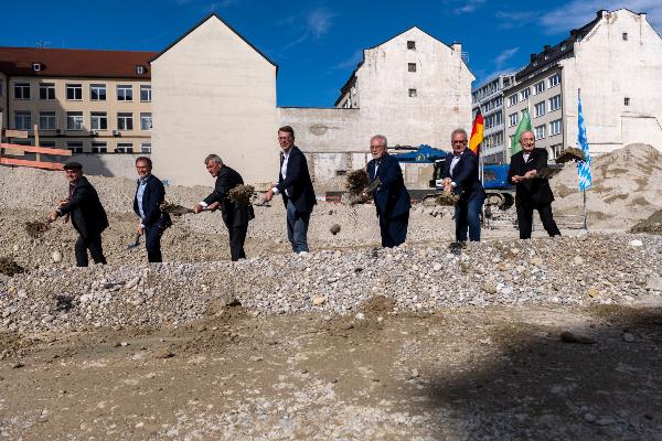 Group photo at the moment of the ground-breaking ceremony, from left to right: Professor Yan Lavallée, Chair of Magmatic Petrology and Volcanology LMU, Thomas Jenkel, Head of the Munich State Building Authority 2, president of LMU Professor Bernd Huber, Bavaria’s State Minister for Science Markus Blume, Professor Donald Bruce Dingwell, Director of the Department for Earth and Environmental Sciences LMU, PProfessor Joris Peters, Chair of Paleoanatomy, Domestication Research and History of Veterinary Medicine at LMU and Director of the Bavarian State Collection for Palaeoanatomy, and Professor Eckhard Gerber of Gerber Architekten