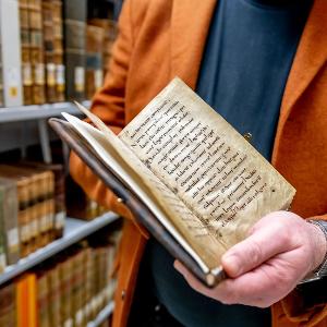 Person mit geöffnetem Buch in der Hand