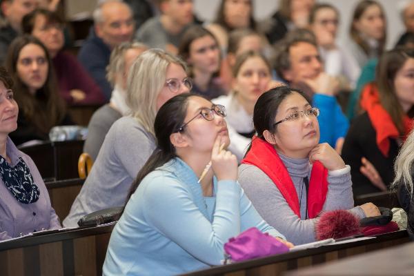 Studierende und Besucher nebeneinander in einer Vorlesung.