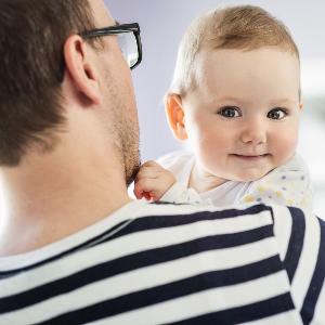 Ein Vater mit Baby auf dem Arm.