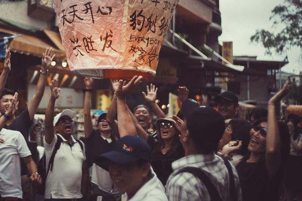 Eine Gruppe von Leuten in Taiwan lässt einen Lampion in die Luft steigen.