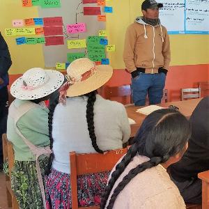Aufnahme von Menschen in einem Raum in Peru, die sich einen Vortrag anhören.