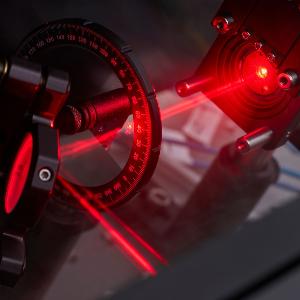Nahaufnahme eines Laboraufbaus mit einem roten Laser