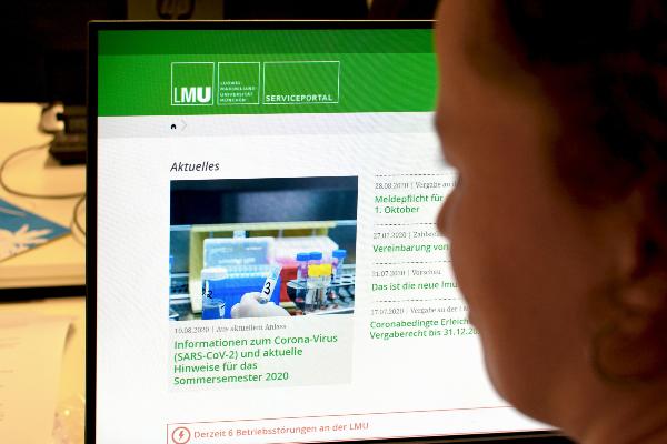 Frau vor Computer informiert sich im Serviceportal der LMU